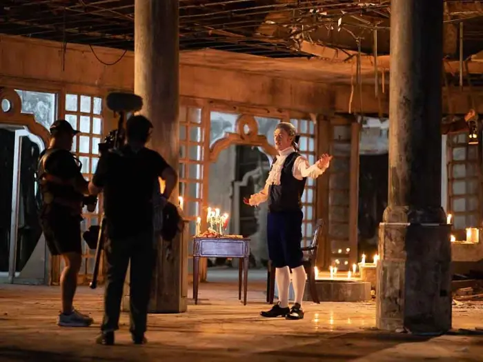 Candlelit costume-drama set with crew